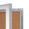 Corner view of enclosed cork bulletin board with swing door